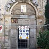 ...ma a interrompere drasticamente l'eleganza dell'ingresso, interviene un�insolita e moderna insegna bianca che recita "riparazioni frigoriferi", sovrastata da un piccolo quadro contenente l'immagine di San Nicola
